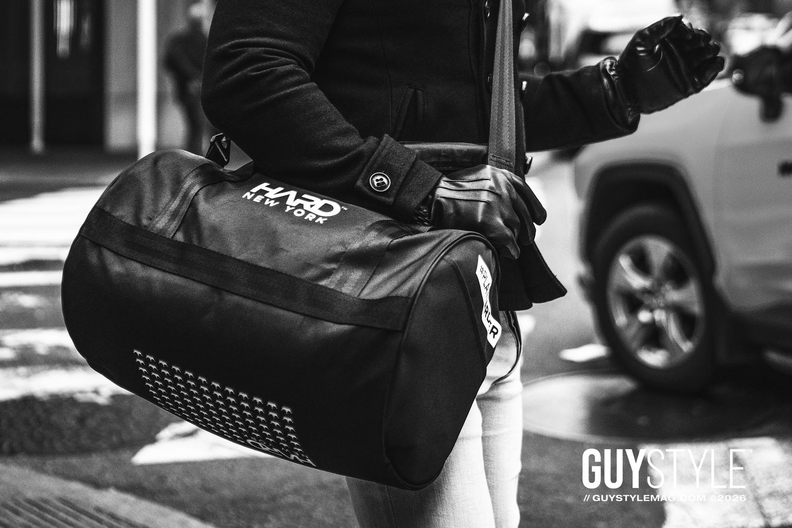 Close-up of Maxwell Alexander carrying a black HARD NEW YORK duffel bag with leather gloves and pale skinny jeans in Manhattan.